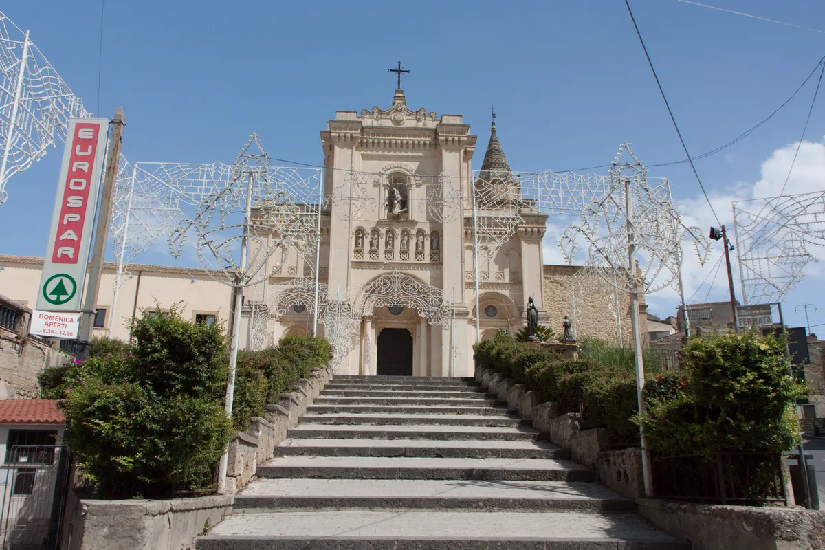 La facciata dell'Abbazia di San Filippo ad Agira, con la scalinata e le luminarie.